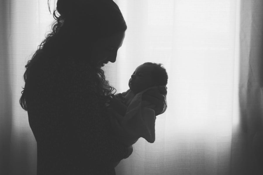 Silhouette d'une maman qui contemple son nouveau-né dans ses bras