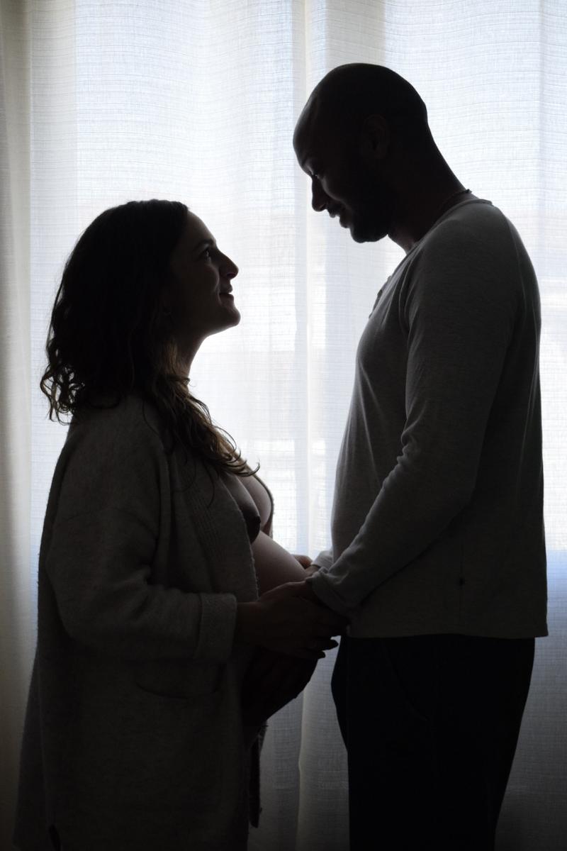 Silhouette d'un couple qui attend un bébé, main dans la main