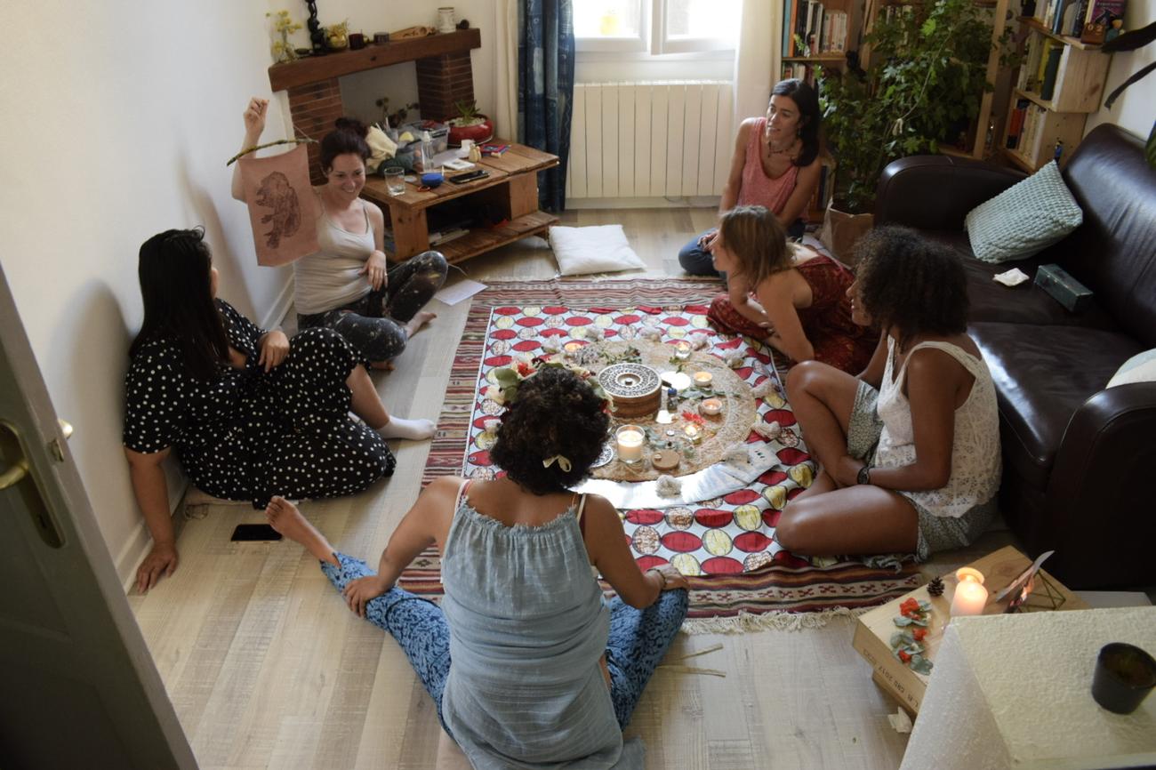 Un cercle de femmes assises autour d'un autel aux bougies pendant un Blessing Way