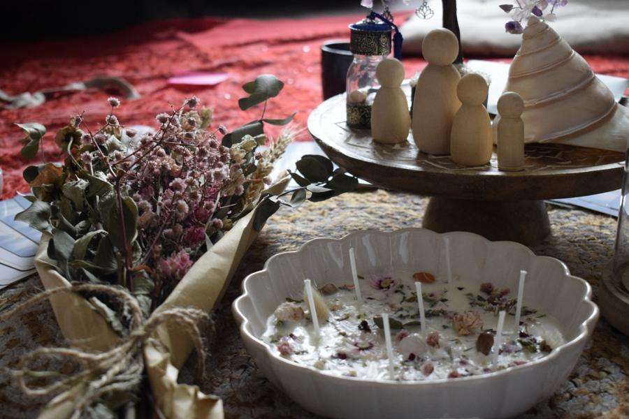 Autel du Blessing Way : bougie aux fleurs séchées, figurines en bois et bouquet