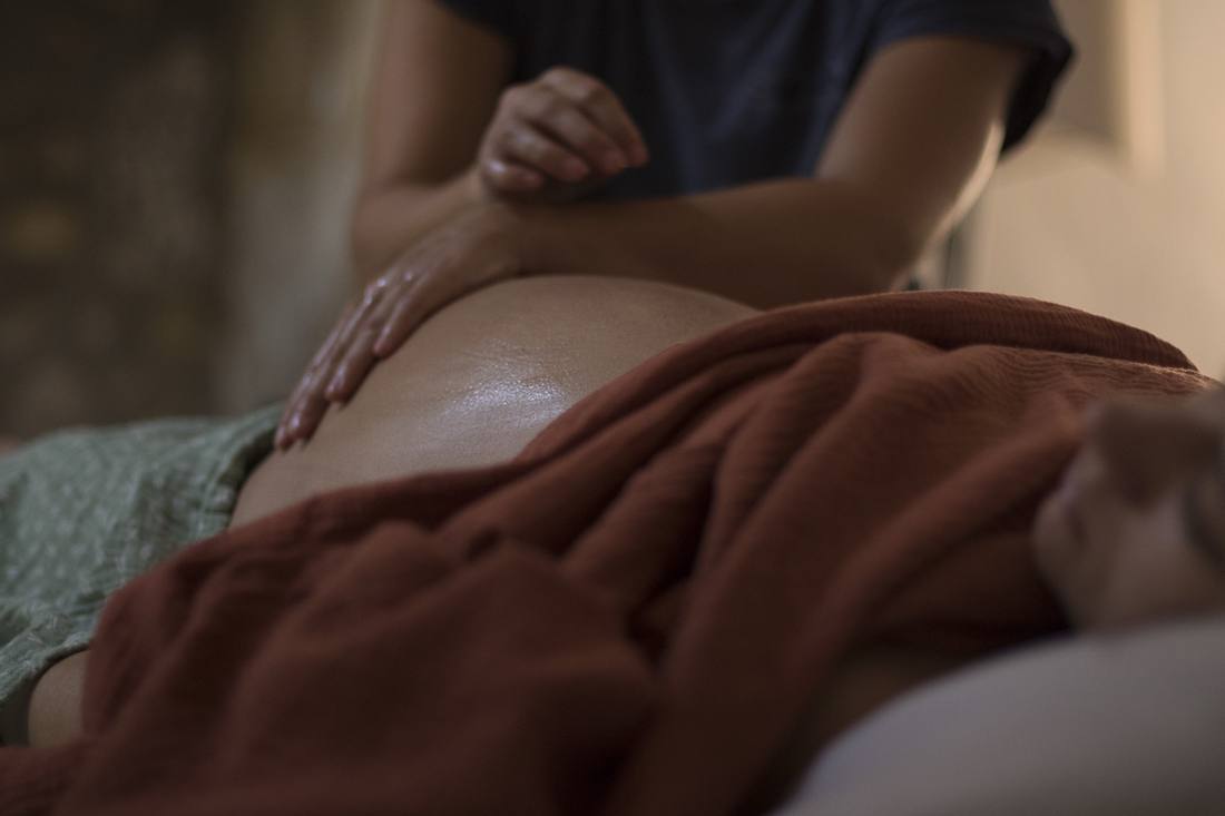 Massage prénatal : les mains d'Andréa sur le ventre d'une future maman
